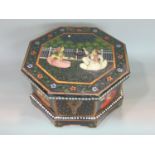 A painted Indian octagonal box, the hinged lid painted with a seated couple, enclosing a segmented