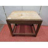 A walnut stool or small occasional table raised on square cut and chamfered supports, with solid