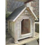 A weathered wooden tongue and groove panelled dog kennel with fixed louvre side vents, 72 cm long