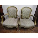 Pair of French open armchairs, the moulded frames with gilded finish, carved floral and other