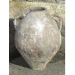 An old terracotta pot-bellied jar with open loop moulded handles and traces of possibly all over