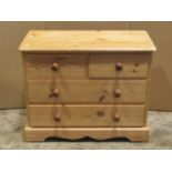 A small stripped pine low bedroom chest of two long and two short drawers together with a matching