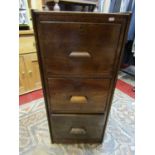 An early 20th century oak three drawer floorstanding pedestal filing cabinet with quarter panelled