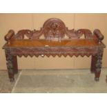 A late Victorian/Edwardian oak low hall bench of rectangular form with turned bobbin arms, carved
