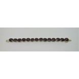 9ct white gold garnet line bracelet, 17.3cm long approx (excluding inner clasp), 32.6g