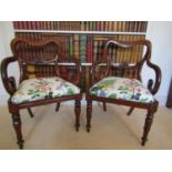 A matched pair of Regency scroll armed elbow chairs, with carved splats, shaped forelegs and