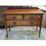 An Edwardian walnut three drawer low side or dressing table raised on simple turned tapered legs and