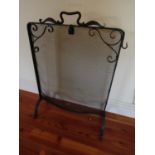 An ironwork fire screen/guard with simple scroll work and further detail in the art nouveau/crafts