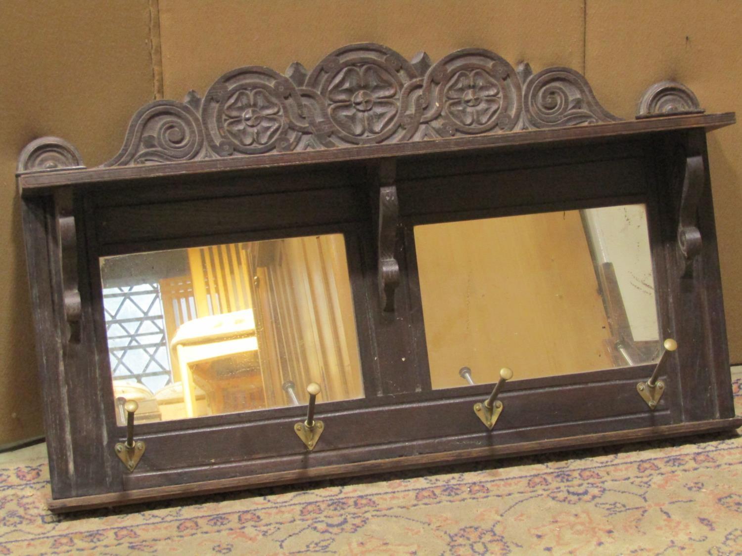 A Victorian oak hall shelf/mirror with carved foliate pediment and moulded frame enclosing two