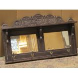 A Victorian oak hall shelf/mirror with carved foliate pediment and moulded frame enclosing two