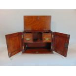 Early 20th century oak smokers cabinet, the two hinged doors with carved relief decoration enclosing