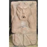 A carved sandstone winged gargoyle/devil with foliate detail, 48 cm high x 28 cm wide