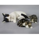 A Winstanley model of a recumbent black and white cat, with painted mark to base, 35cm approx, a