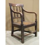 A 19th century country made bar and moulded stick back open elbow chair with central pierced