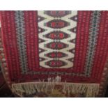 A Bokhara type rug with central geometric medallion field with red borders, 150 x 95cm