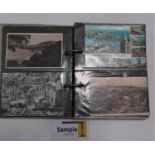 An album containing a quantity of mixed postcards, both colour and black and white examples,