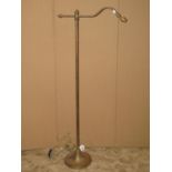 A brass standard/reading lamp with tubular stem and weighted disc shaped platform base