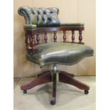 A reproduction green leather upholstered swivel office/desk chair with scrolled button turned
