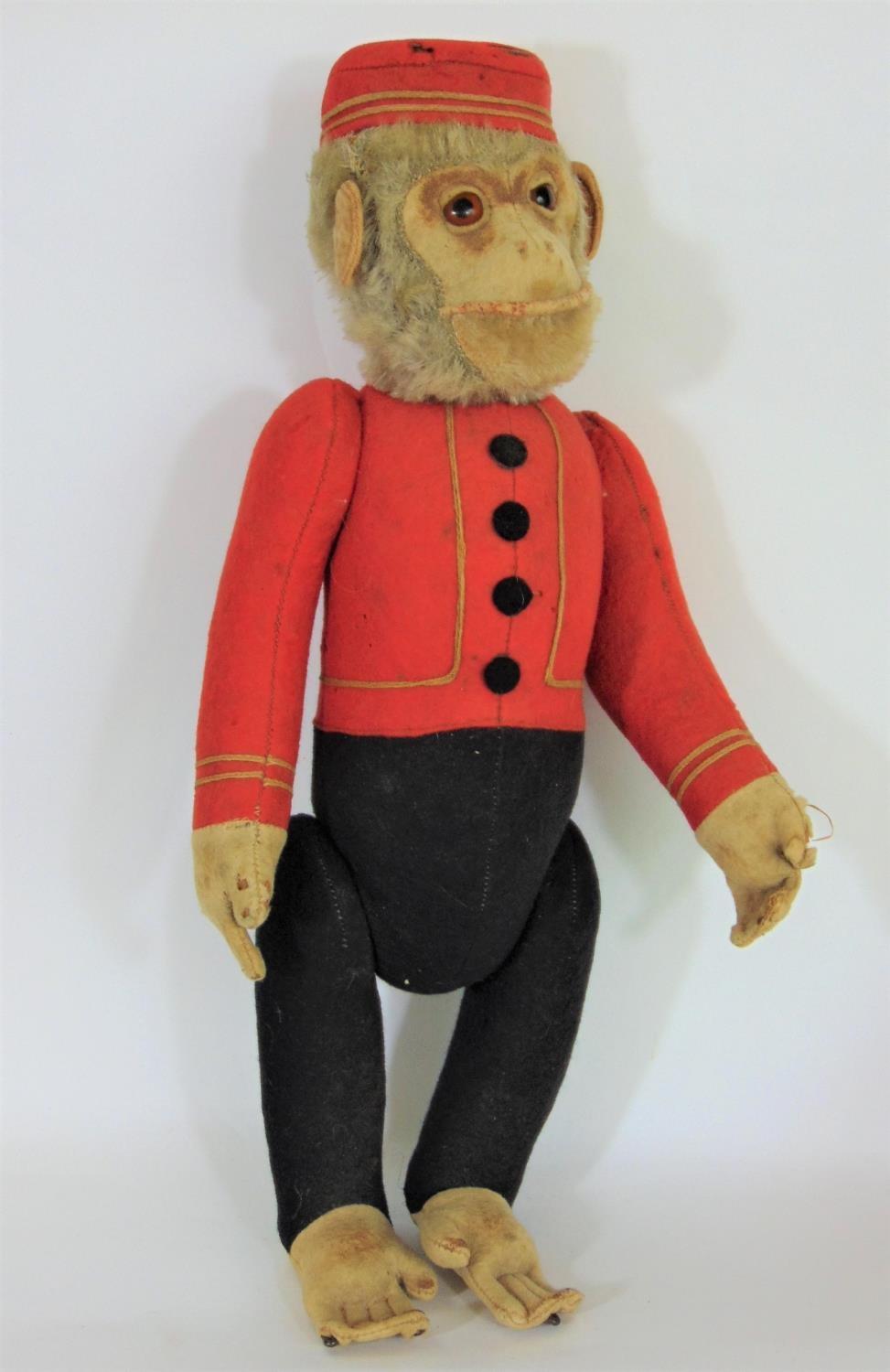 Schucco Bellhop Yes/ No monkey C1920's with brown glass eyes, fur head, felt face, in red and