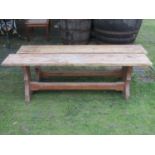A pair of pine benches with rectangular plank seats, raised on shaped supports united by a chamfered