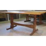 A pine refectory table, the rectangular top raised on shaped supports united by a central stretcher,