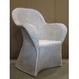 A vintage wicker chair with shaped outline and cream painted finish