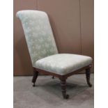A Victorian rosewood nursing/prayer chair with pale green ground repeating sprig patterned