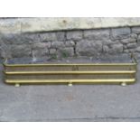 A polished brass fender with pierced Gothic tracery grill, 124cm wide (full length) internal