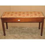 An Edwardian mahogany duet piano stool with shallow upholstered hinged box seat raised on square