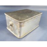Edwardian silver casket with twin lion head ring handles, and gadrooned rims, the hinged lid