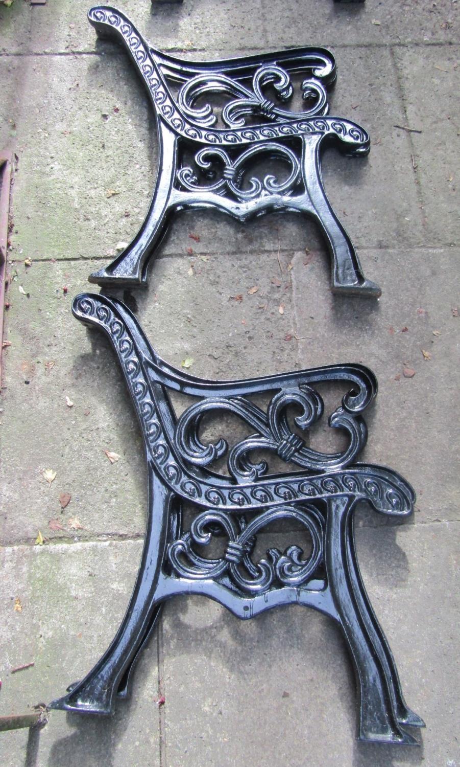 A two seat garden bench with timber lathes and decorative pierced cast iron ends, 130 cm long - Image 2 of 3