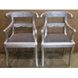 A pair of Regency style open elbow chairs, unusually embossed, brightly tin clad with ramshead