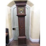 A Georgian oak longcase clock, the case with later carved detail, enclosing a 28cm square brass