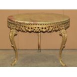A low occasional table of circular form with onyx top, pierced scrolling acanthus cast gilt metal