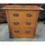 A small Edwardian Arts & Crafts style dressing chest of three long drawers beneath an overhanging