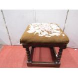 An antique oak stool frame with barley twist supports and later tapestry top, 35cm