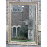 A contemporary gilt framed wall mirror of rectangular form with bevelled edge plate and foliate