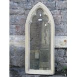 A novel contemporary wall mirror in the form of a lancet shaped gothic window enclosing a distressed