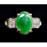 A JADE AND DIAMOND DRESS RING, CENTRALLY SET WITH AN OVAL CABOCHON CUT JADE, MEASURING APPROXIMATELY