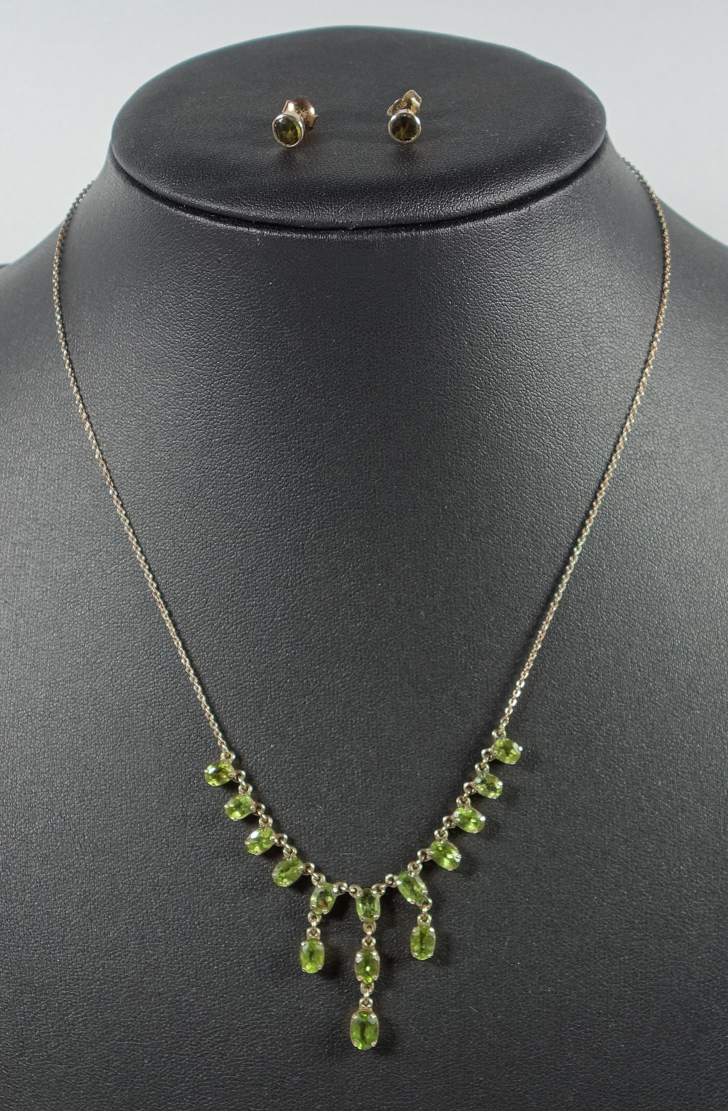 A PERIDOT FRINGE NECKLACE, SET WITH FIFTEEN OVAL CUT PERIDOT ON AN INTEGRATED 9 CT YELLOW GOLD