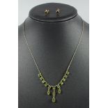 A PERIDOT FRINGE NECKLACE, SET WITH FIFTEEN OVAL CUT PERIDOT ON AN INTEGRATED 9 CT YELLOW GOLD