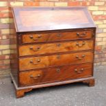 GEORGE III MAHOGANY BUREAU WITH A CROSSBANDED FALL FRONT DISCLOSING A PANEL DOOR, TWO SECRET