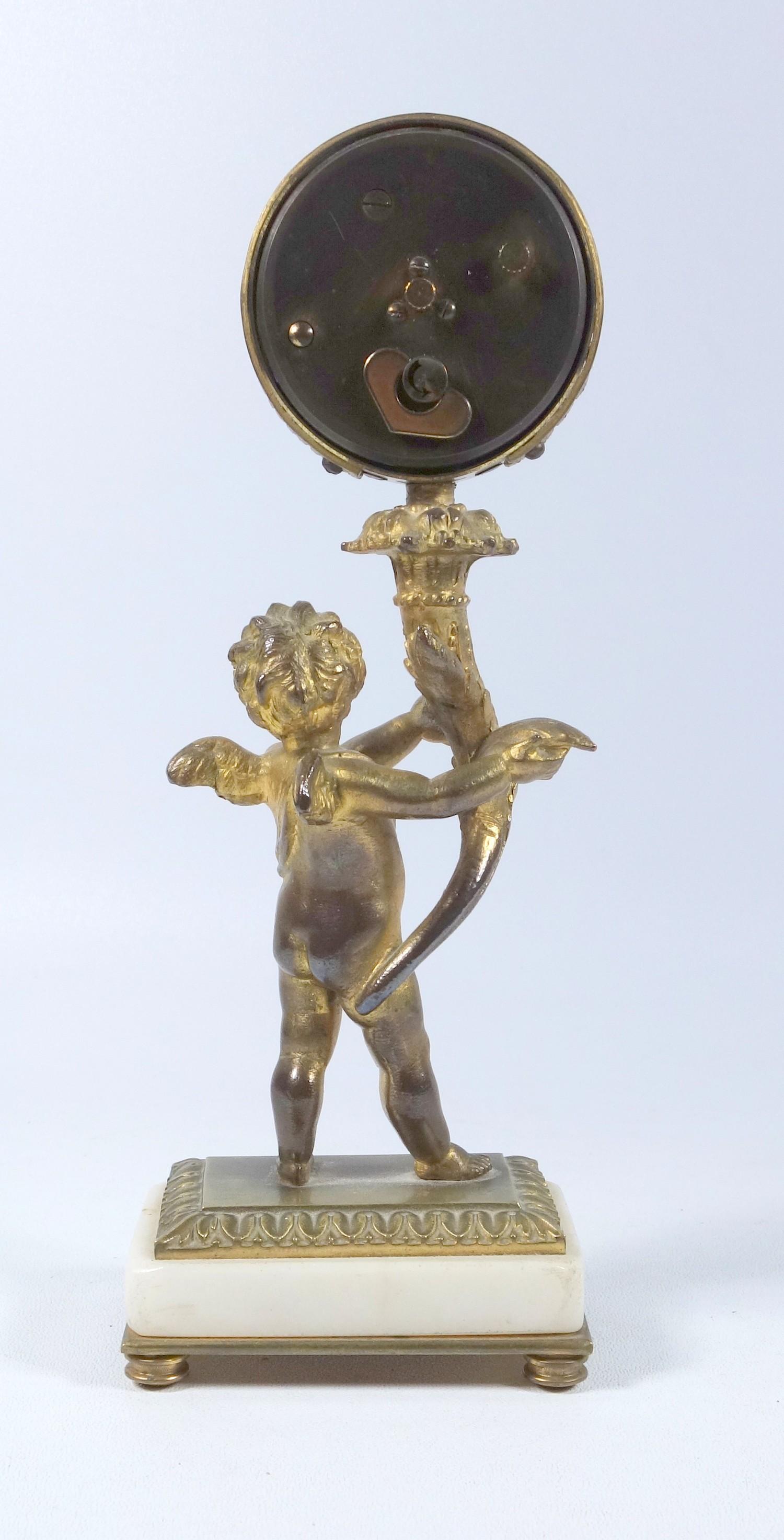 FRENCH GILT BRONZE ALARM CLOCK WITH A CHERUB HOLDING A CORNUCOPIA SUPPORTING A CIRCULAR DIAL - Image 2 of 2