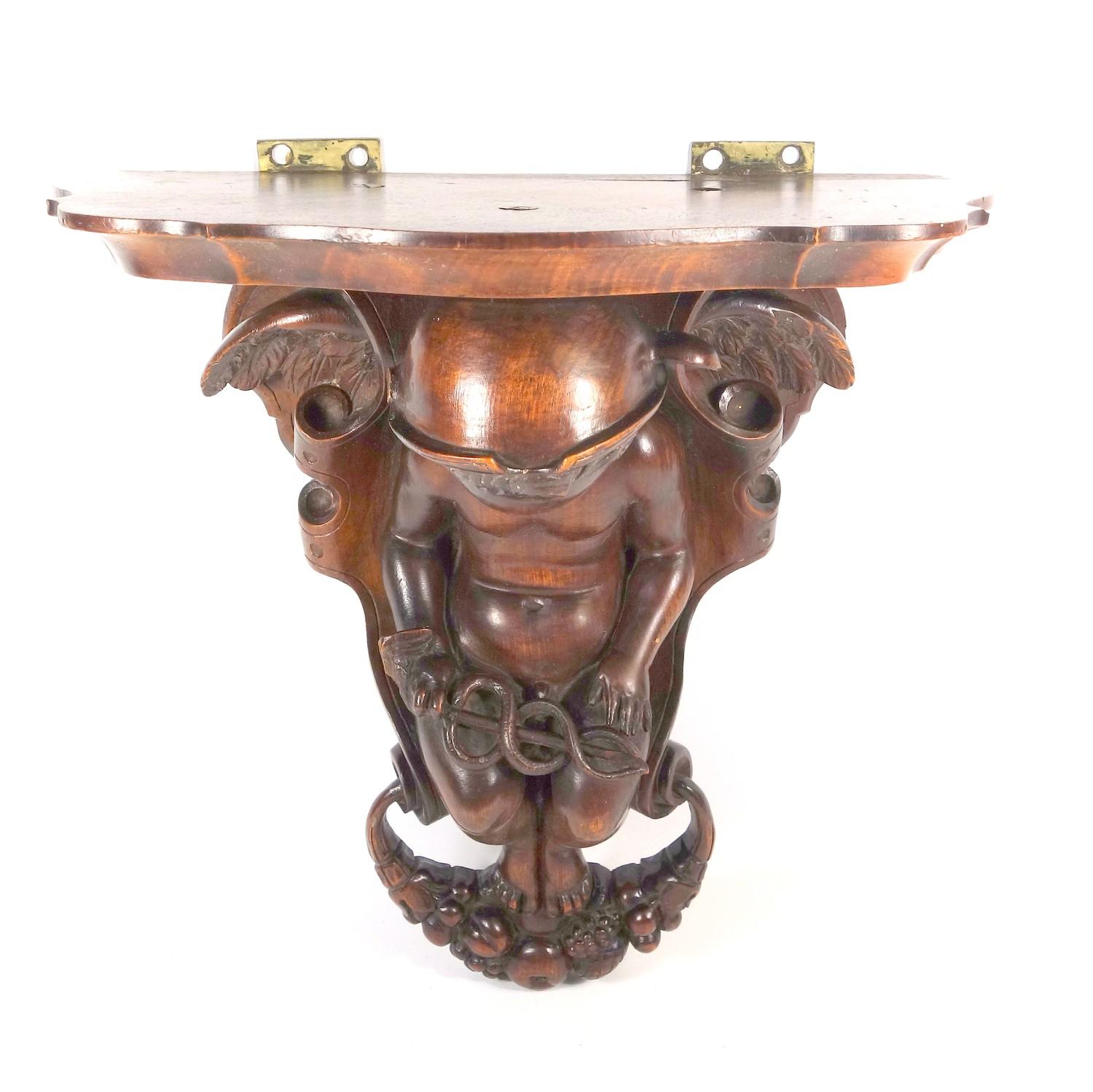 19TH CENTURY ITALIAN CARVED WALNUT WALL BRACKET WITH A FIGURE OF MERCURY SEATED AND HOLDING A