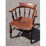 VICTORIAN SMOKER'S BOW ELM ARMCHAIR WITH A SPINDLE BACK ON TURNED TAPERING LEGS AND TWIN