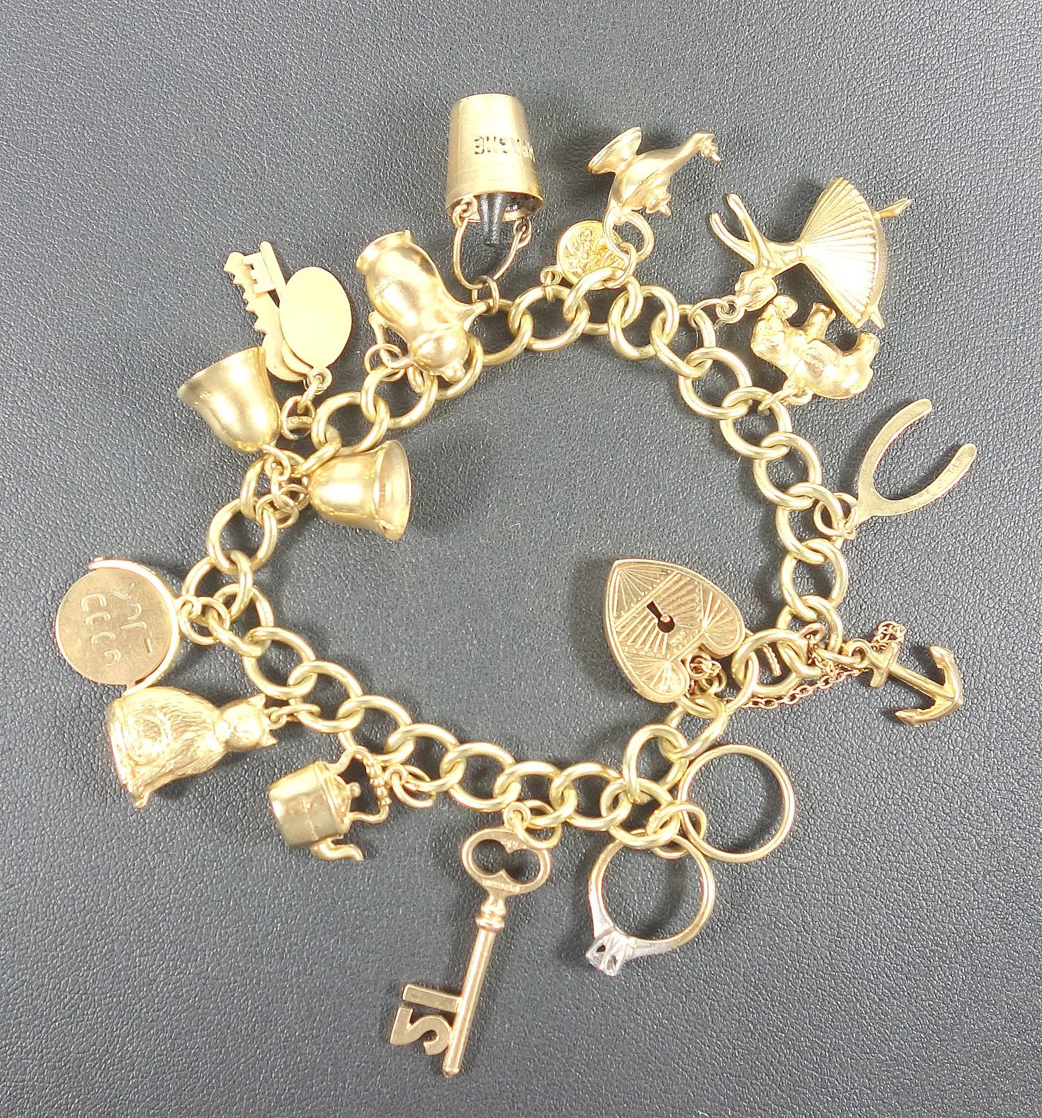 9 CT GOLD CHARM BRACELET WITH FIFTEEN CHARMS, CASED, 31.7 GRAMS