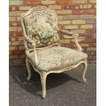 FRENCH LOUIS XV STYLE CREAM AND GILT OPEN ARMCHAIR WITH A NEEDLEWORK SHAPED ARCHED BACK DEPICTING