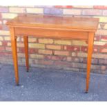 EDWARDIAN MAHOGANY CARD TABLE WITH A FOLDING RECTANGULAR TOP, ON TAPERING LEGS AND CASTORS (H. 74