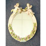 19TH CENTURY GERMAN PORCELAIN OVAL WALL MIRROR, PROFUSELY DECORATED WITH FLOWERS AND FOLIAGE,