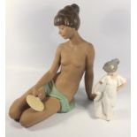 NAO PORCELAIN FIGURE OF A NAKED POLYNESIAN WOMAN SEATED, WITH A DRAPE HOLDING A FAN NOW DETACHED (H.